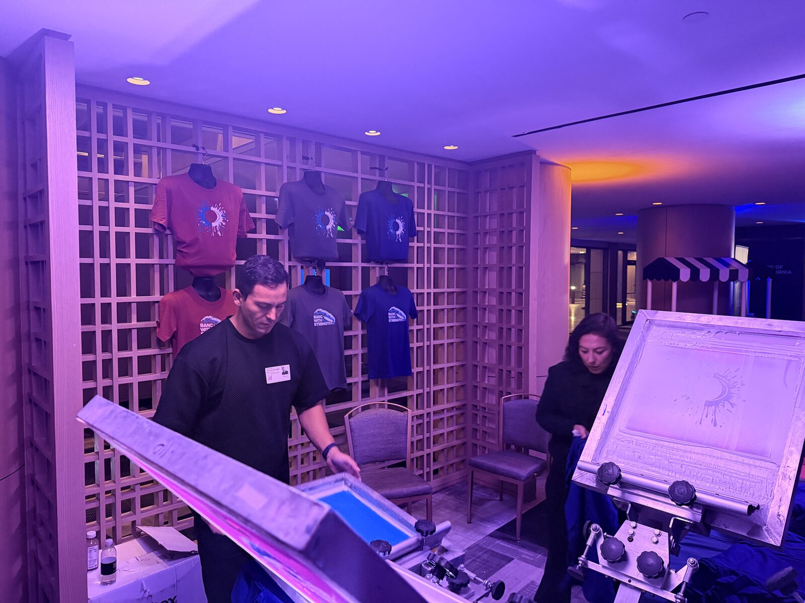 Wall of custom event shirts printed live at an on-site swag station