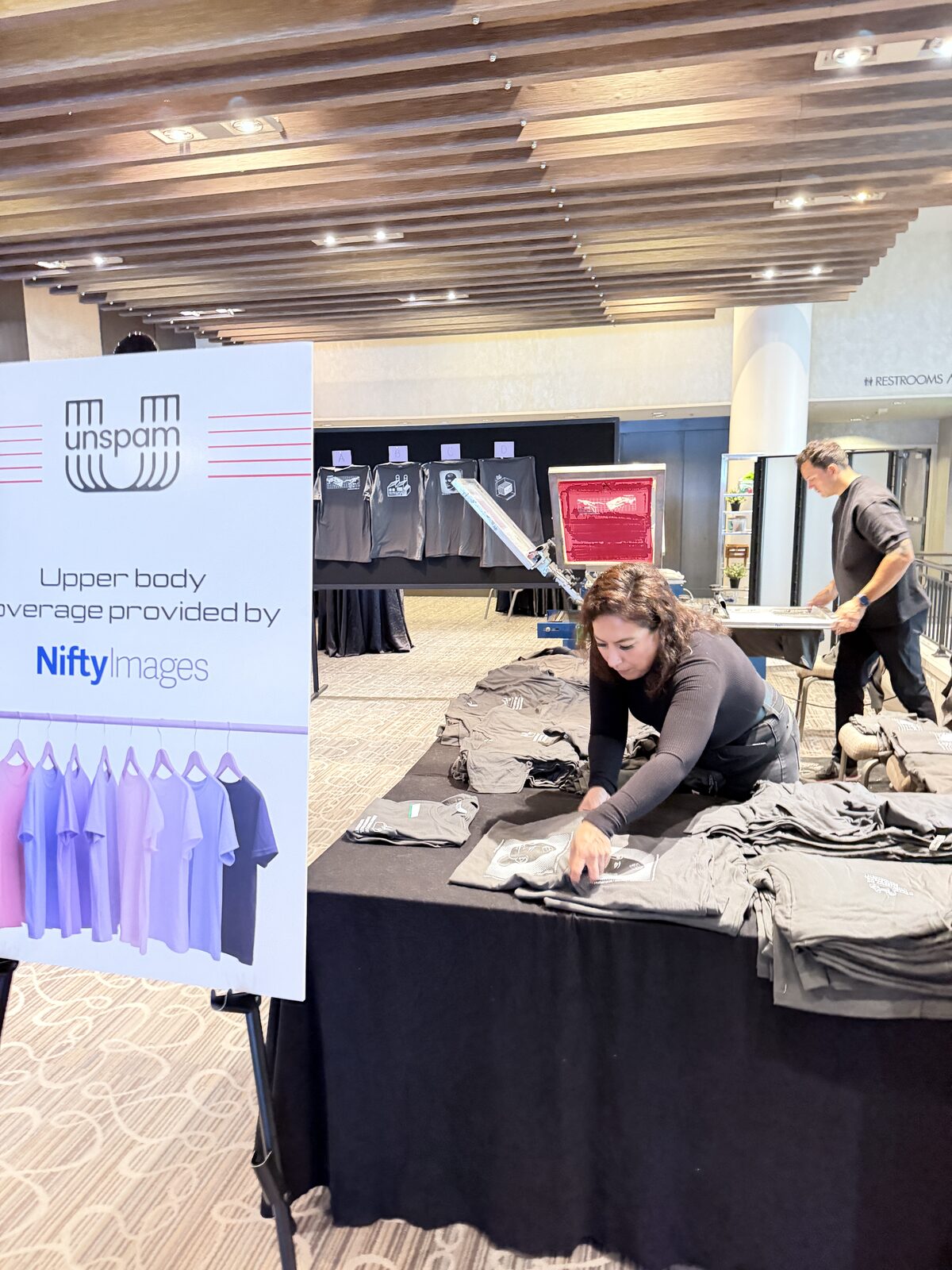 Conference merch table stacked with printed shirts ready for pickup